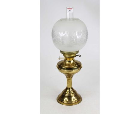 A brass oil lamp, having an etched glass shade, height 55cm