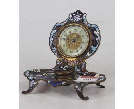 An early 20th century French enamel desk stand, inset with a clock with inkwell below, on outswept feet 