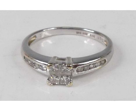 A contemporary 18ct white gold diamond dress ring, arranged as four Princess cuts in a square setting, the shoulders further 