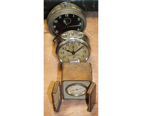 An early 20th century German alarm clock, having a black papered dial with Arabic numerals, h.15cm, togetehr with two others 