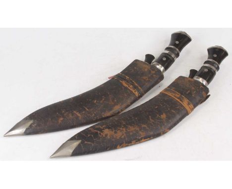 A 20th century kukri, having a polished blade with engraved decoration and lion mask capped lacquered horn handle, with leath