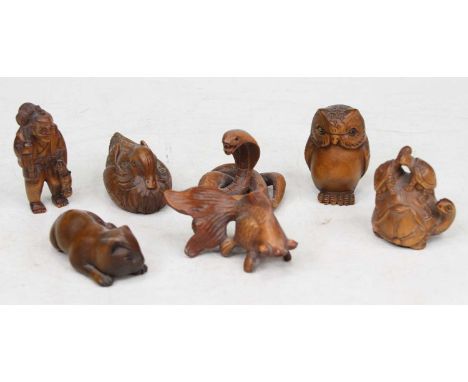 A collection of seven Japanese carved boxwood netsuke to include an example in the form of a coiled cobra, signed to the unde