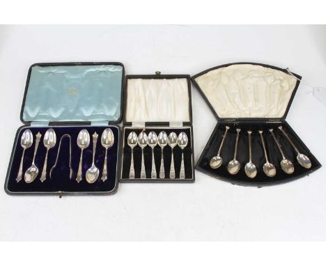 A cased set of six silver teaspoons with sugar bows, together with a cased set of six silver coffee spoons, and a cased set o