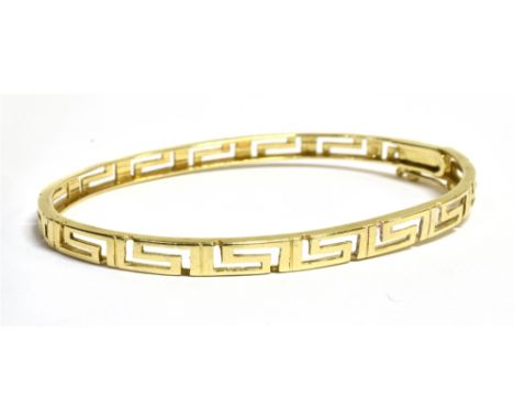 A YELLOW METAL GREEK KEY BANGLE The bangle with safety slide clasp and faded 585 markings, bangle diameter approx. 6.5cm, wid