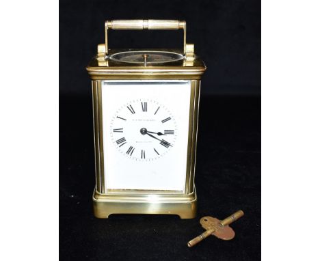 A BRASS CASED CARRIAGE CLOCK WITH REPEAT MECHANISM  the enamel dial signed 'W H SMITH &amp; SON BLACKHEATH',  the French 8-da