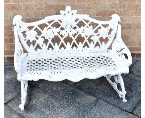 A SMALL COALBROOKDALE STYLE CAST METAL BENCH  painted white, the back cast with leaves and berries on a lattice frame, 97cm w