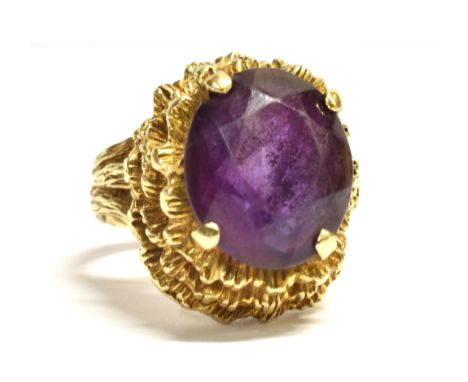 A VINTAGE 9CT GOLD AMETHYST COCKTAIL RING the oval facetted amethyst measuring 1.5cm by 1.1cm, the shank with faded 9.375 Lon