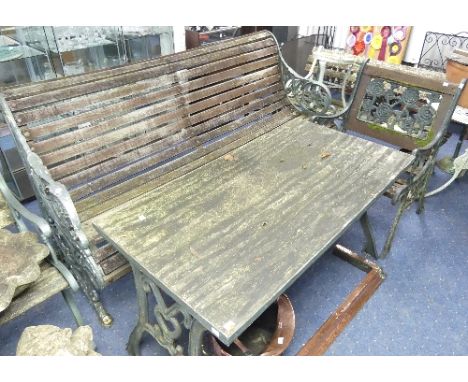 A pair of vintage cast-iron framed wooden Garden Chairs, the frame painted green, with decorative pierced back splat depictin