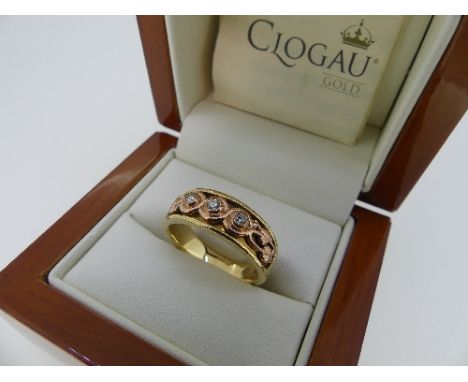 Clogau Gold; A 9ct yellow and rose gold 'Tree of Life' Trilogy Ring, the three diamonds collet set amongst scrolling foliate 