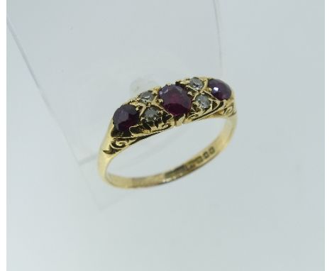 A graduated three stone Ruby Ring, each set with two diamonds between, all mounted in 18ct yellow gold, Size Q.