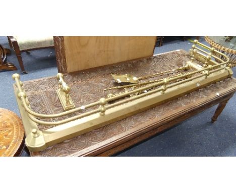 An antique brass Fire Fender, 60in wide x 17in deep x 7in high, together with two matching brass Fire Dogs, brass Fire Poker,