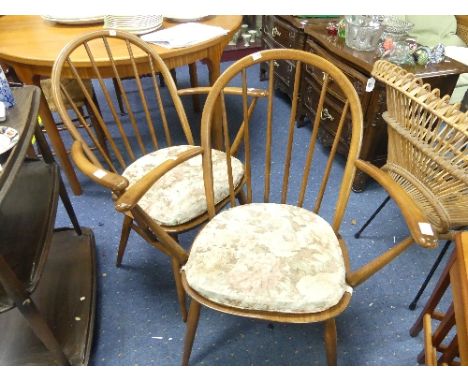 A pair of Ercol blonde elm Stick Back Arm Chairs, each with six sticks and with floral cushion pads, 27in (69cm) wide x 17in 