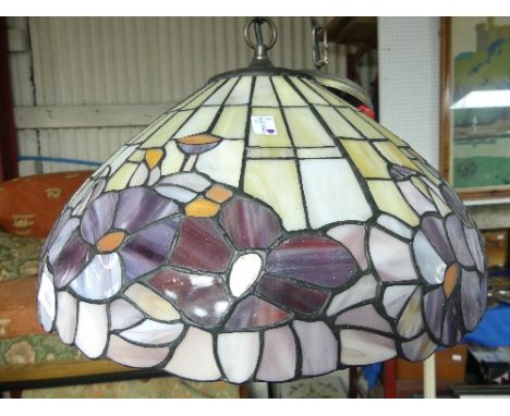 A Tiffany-style hanging Pendant Lamp-shade, with cream/yellow base colour, bordred by vibrant lilac and orange floral decorat