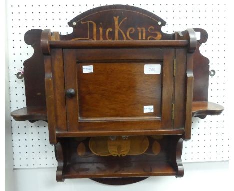 An Arts &amp; Crafts 'Dickens' walnut hanging wall Cupboard, the central panelled door and shelves with marquetry and mother-