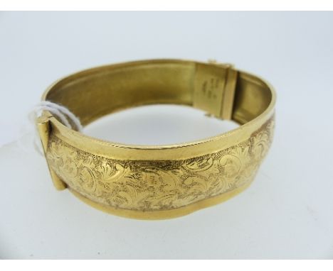 An 18ct yellow gold Hinged Bangle, with foliate engraved decoration, Swedish hallmarks for 1944, approx weight 25g. 