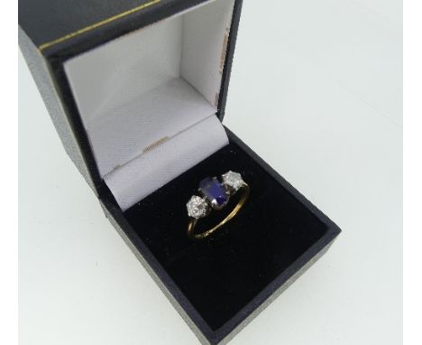 A three stone sapphire and diamond Ring, the oval facetted (synthetic) sapphire, with an old cut diamond on either side, the 