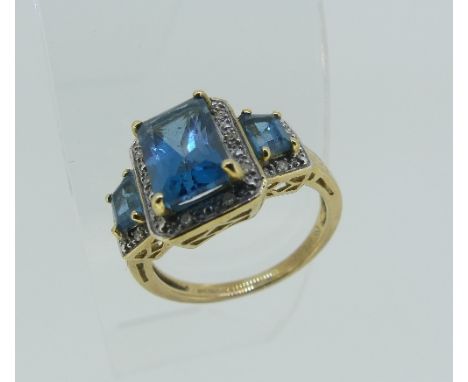 A graduated three stone Topaz Dress Ring, of stepped form, each stone with small diamond point surround, all mounted in 9ct g