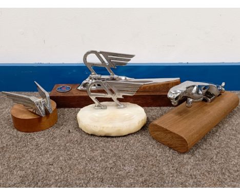 An Austin and onyx ashtray, 12.5 cm wide, and three other car emblems, mounted on wooden bases (4)  Please see our terms and 