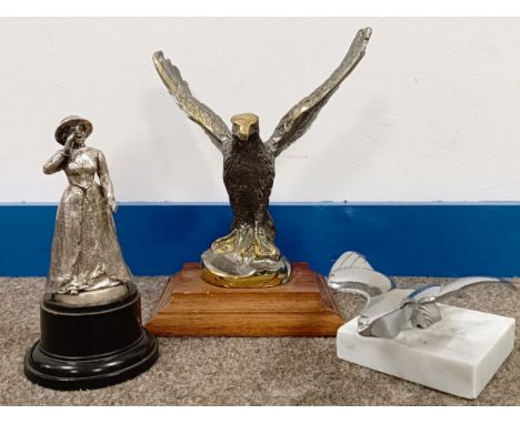 A chrome bonnet emblem, in the form of a bird, on a marble base, 6 cm high, and two others similar (3)  Please see our terms 