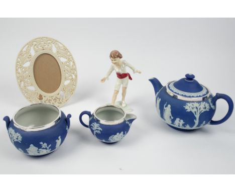 A Wedgwood blue Jasper ware three piece tea set with silver rims, a Royal Worcester figure Masquerade 3359 and Lenox oval por