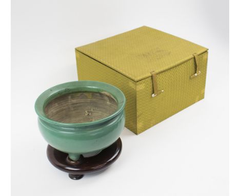 ORIENTAL BOWL, green glazed ceramic, raised on three feet, 18cm diam. x 10.5cm H plus wooden display stand and box.