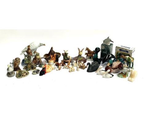 A collection of animal figurines, to include cats, Poole pottery dolphin and duck, Highbank porcelain dolphin etc 