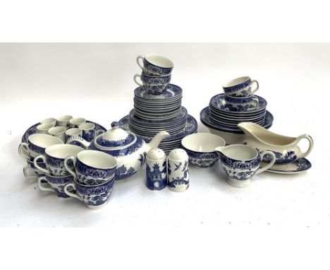 A blue and white Willow pattern dinner service, including various sizes of plates, bowls, teacups, saucers, meat plates, teap