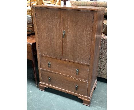 An early 20th century limed oak cupboard, two drawers below, ogee bracket feet, 76x43x117cmH 