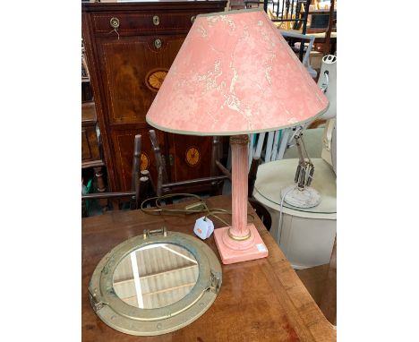 A pink ceramic table lamp with corinthian column and pink marble effect shade, 53cmH; together with a porthole mirror, 29cmW 