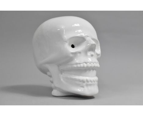 A Modern Ceramic Novelty White Glazed Money Box in the Form of a Skull, 17.5cms High 