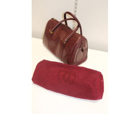 A Cartier Boston Bag – Oxblood leather.  Each end of the bag is embossed with the signature Cartier “CC”.  Vintage item in go