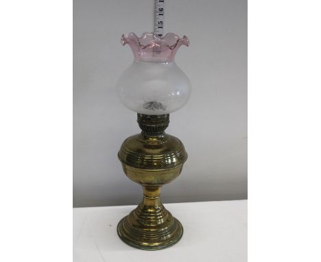 An antique brass and glass oil lamp 
