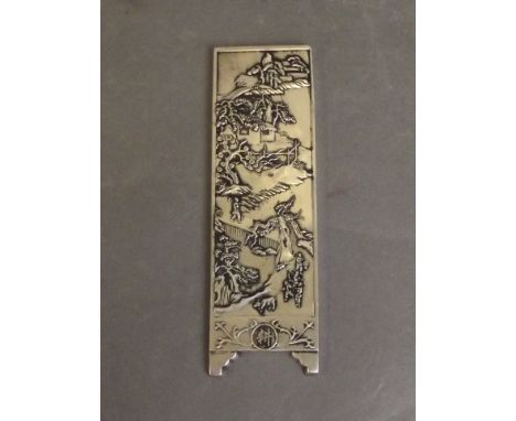 A Chinese silver scroll weight with raised decoration of a landscape, 5¾'' long