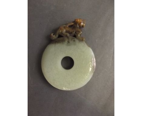 A Chinese pi-disc shaped jade pendant with a carved kylin surmount, 2¾'' long