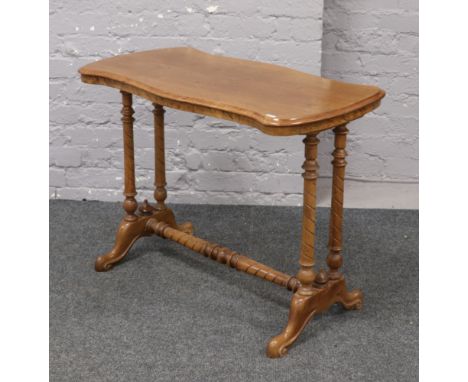 A Victorian mahogany stretcher table raised on turned and carved supports.