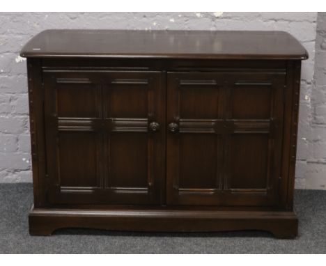 A dark oak Ercol hifi cabinet, W 107cm x D 31cm x H 49cm.