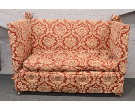 A two seater drop side sofa in claret damask upholstery.