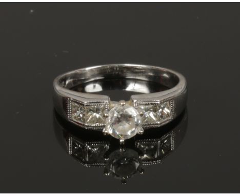 A ladies 18ct white gold engagement ring set with centre round cut solitaire 0.64ct diamond with four cushion cut diamond sho