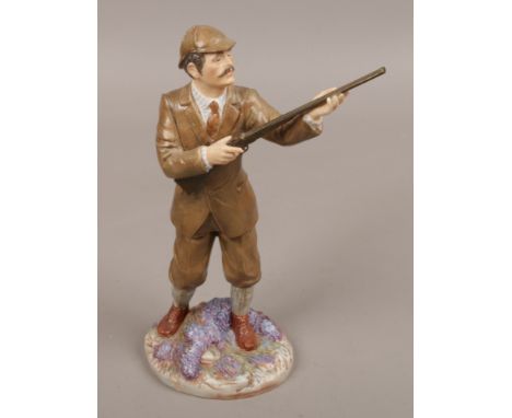 A ceramic Coalport figurine of a man holding a gun titled The Shooter.