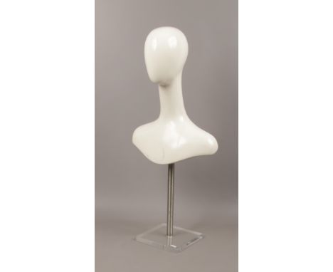 A minimalist head and shoulders shop mannequin on perspex plinth.