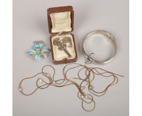 A silver bangle, along with a white metal cross on chain, enamel brooch and a gilt necklace.