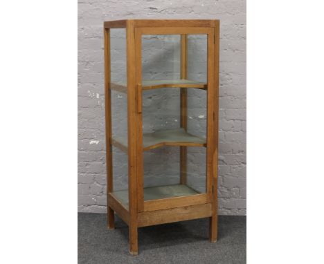 A light oak display cabinet with V shaped shelves, 146cm x 61cm x 52cm.