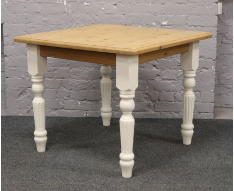 A part painted pine dining table with turned and reeded legs.