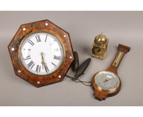 An octagonal twin weight wall clock striking on a bell, brass lantern clock and a barometer.