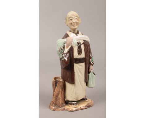 A ceramic nodding figure of a monk.