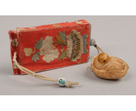 A Japanese inro with embroidered silk decoration and a netsuke formed as a chic.