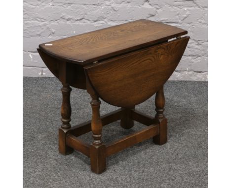 A carved and turned oak drop leaf occasional table.