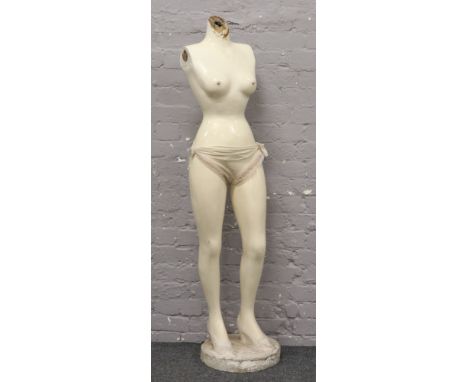 A vintage female shop mannequin torso and legs on plinth.