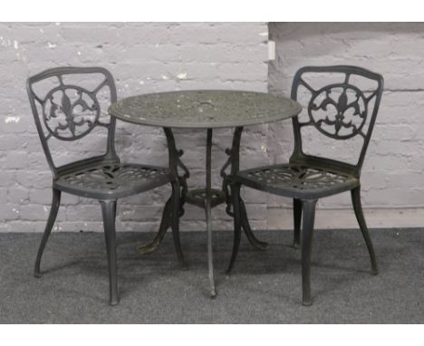 A cast aluminium garden table and two chairs.