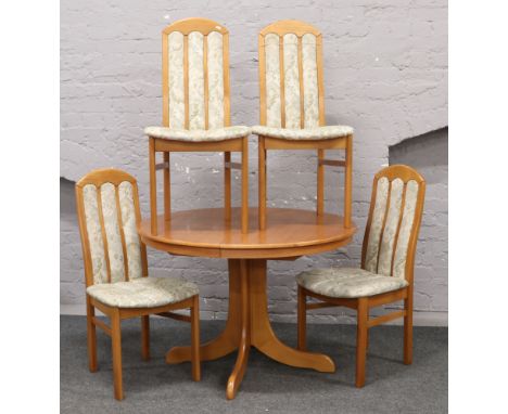 A teak centre pedestal extending dining table, along with a set of four hardwood chairs with upholstered seats and backs.